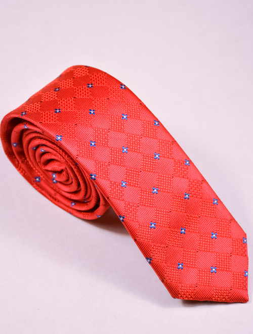 Czerwony krawat w drobne niebieskie kwadraty.